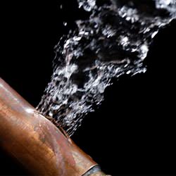 A bursting copper pipe in Thousand Oaks, with water gushing out.