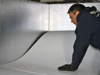 A contractor installing TerraBlock™ floor insulation in a Oak View crawl space
